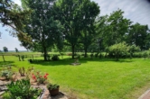 Blick in den Garten - Gemeinde Berne: Außergewöhnliche Eigentumswohnung mit großen Nebengebäuden!