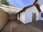 Außenansicht mit Carport - Wüsting: 2-Zimmer-Erdgeschosswohnung mit Terrasse und Carport